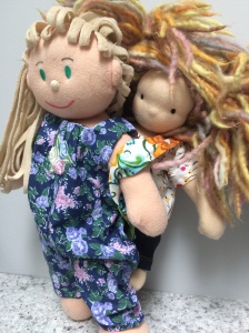 Soft body doll wearing a smaller Waldorf style doll in a doll baby carrier